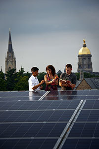 Professor Prashant Kamat, left, works with graduate students on the solar panels on the roof of Stinson-Remick Hall of Engineering