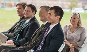 John Affleck-Graves, middle, sits with Mayor Pete Buttigieg, second from right, at the ND Turbomachinery Facility groundbreaking ceremony