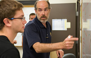 Daniel Karmgard, research assistant professor of physics, instructs a student at the Notre Dame QuarkNet Center
