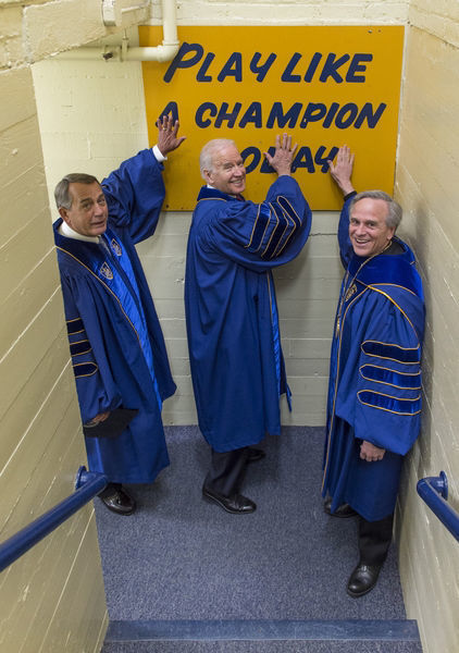 President Rev. John Jenkins, C.S.C., and Laetare Medal recipients John Boehner and Vice President Joe Biden touch the Play Like a Champion sign on their way out of the locker room for the 2016 Commencement Ceremony