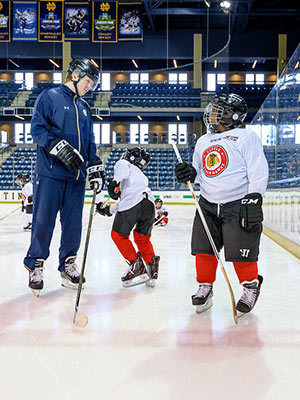 Jon Williams III, right, tries out his new skates on the main ice at Compton Family Ice Arena. Photo by Matt Cashore/University of Notre Dame.