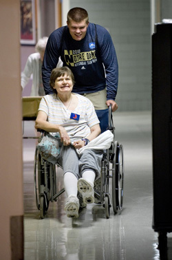 Notre Dame Football player Bruce Heggie visits with a resident of Healthwin Specialized Care Facility