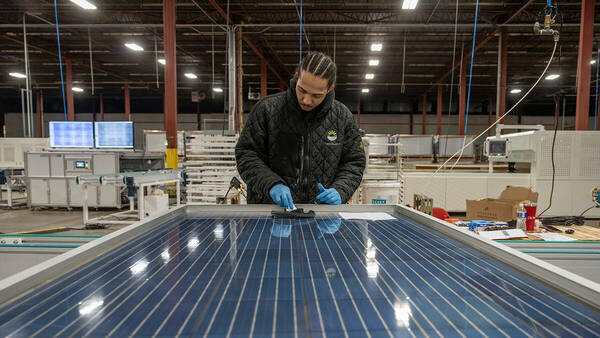 A man assembling a solar panel.