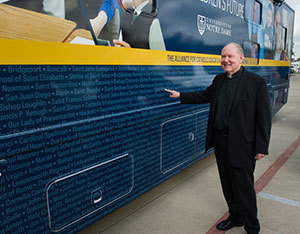 Father Tim Scully stands outside the ACE bus