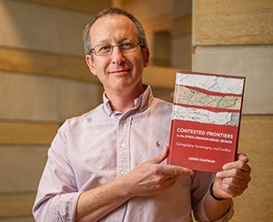 Associate Professor Asher Kaufman holds his new book, "Contested Frontiers in the Syria-Lebanon-Israel Region: Cartography, Sovereignty and Conflict"