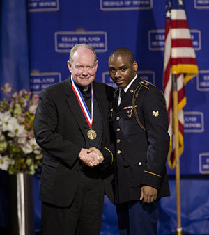 Rev. Timothy Scully, C.S.C., is pictured with a member of the Joint Service Color Guard, who presented him with his Ellis Island Medal of Honor. Photo courtesy of the National Ethnic Coalition of Organizations.