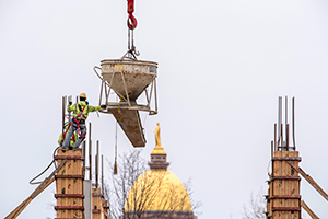 Workers prepare to pour cement into a support column at McCourtney Hall construction site
