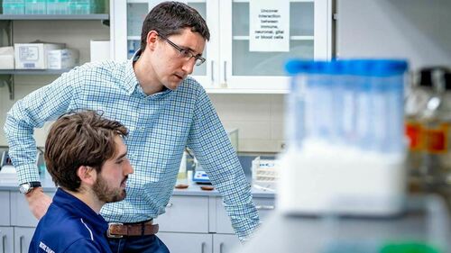 Cody Smith chats with a graduate student in his lab. Photo by Matt Cashore/University of Notre Dame.