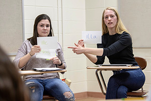 Notre Dame students Emma Ferdinandi and Juliana Vossenberg (right) use cue cards to teach Latin words to Clay International Academy students. Photo by Barbara Johnston/University of Notre Dame.