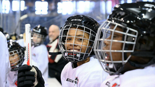 Curtis Lee, 11, smiles on the bench at the Compton Family Ice Arena. Photo by Matt Cashore/University of Notre Dame.