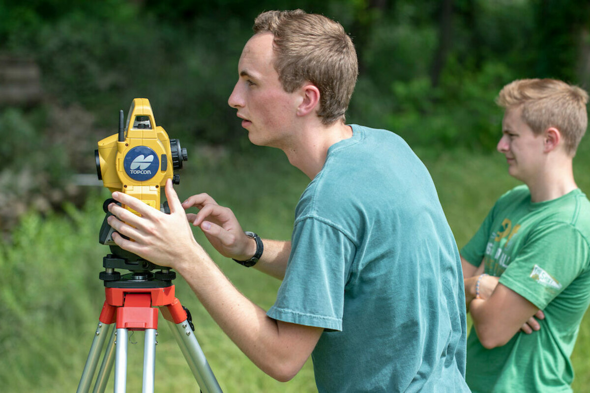 Student interns with the Center for Civic Innovation and Bowman Creek Educational Ecosystem, Finn Cavanaugh and Tommy Crooks (right) from Notre Dame, survey an area of Bowman Creek in South Bend. Photo by Barbara Johnston/University of Notre Dame.