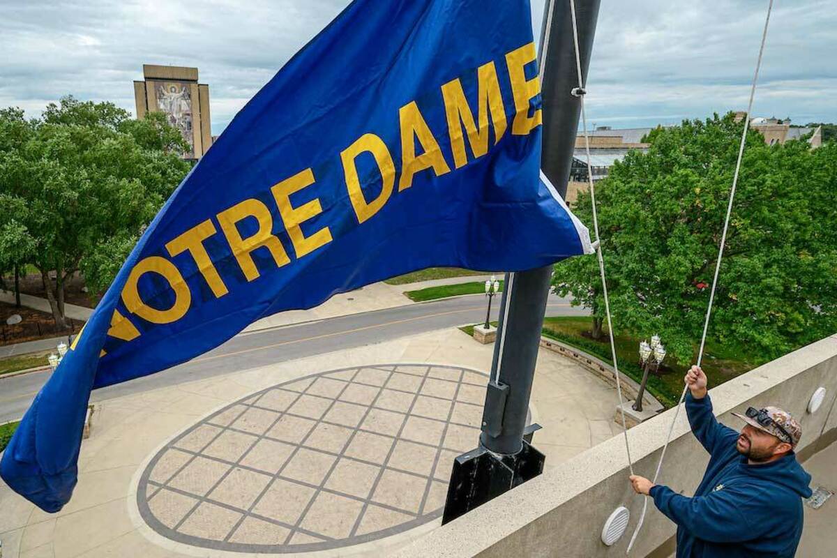 Notre Dame Stadium groundskeeper Robert "Chip" Miltenberger raises the Notre Dame pennant on the Monday of the first game week of the 2019 football season. Photo by Matt Cashore/University of Notre Dame.