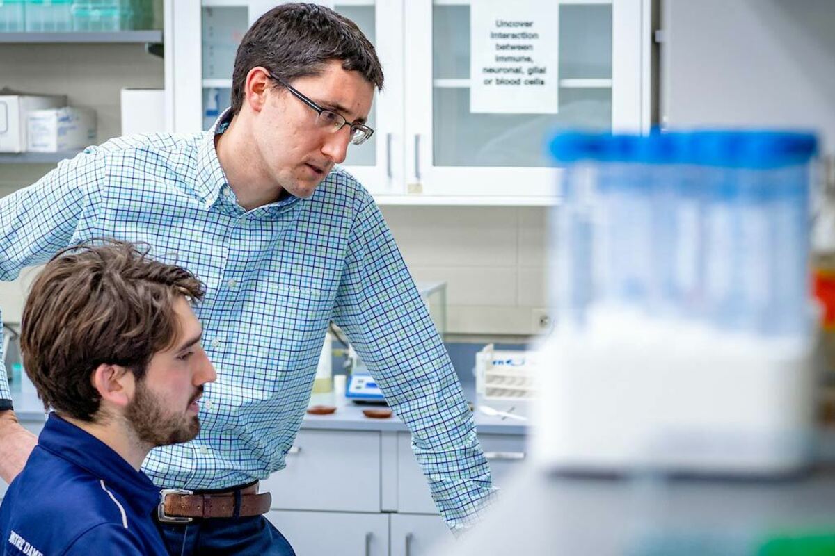 Cody Smith works with a student in his lab.