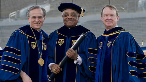 Wilton Gregory, Archbishop of Atlanta, receives an honorary doctor of laws degree from Notre Dame President Rev. John Jenkins, C.S.C., left, and Notre Dame Chairman of the Board of Trustees Richard Notebaert at the 2012 Commencement ceremony at Notre Dame Stadium. Photo by Matt Cashore/University of Notre Dame.
