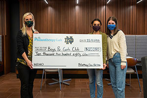 Jacqueline Kronk, Maya Elliott and Maria Teel hold a check for the Boys & Girls Club. Photo by Barbara Johnston/University of Notre Dame.