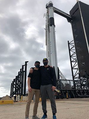 Lucas Hopkins (left) and his brother Ryan stand in front of the rocket their father rode into space Nov. 15.