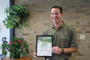 Chip Farrell holding Certificate of Recognition from IDEM