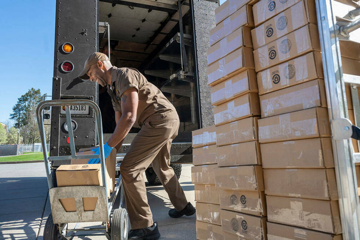 UPS workers loading Student Memory boxes for delivery. (Photo by Barbara Johnston/University of Notre Dame)