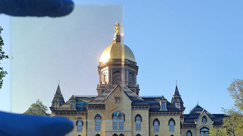 Notre Dame’s Golden Dome partially photographed through a sample (top left) of the TRC coating.