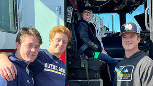 Casey Doyle, Maxim Manyak, Ian McMillan and Kevin Lynch pose by a fire truck.