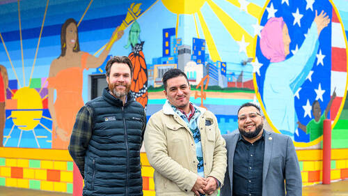 Michael Hebbeler, Freddy Rodriguez and Juan Constantino pose in front of the mural outside La Casa de Amistad.