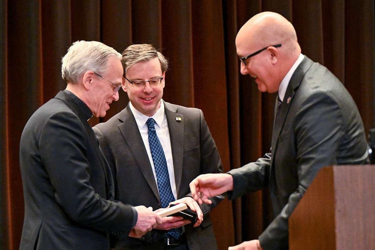 University of Notre Dame President Rev. John I. Jenkins, C.S.C., left, receives keys to the cities of South Bend and Mishawaka from Mayors James Mueller and Dave Wood.