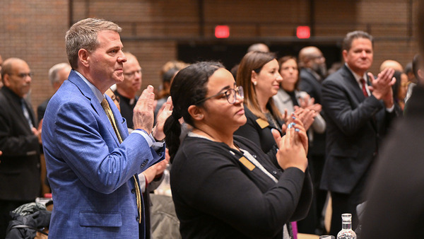 Notre Dame Executive Vice President Shannon Cullinan, left, and others applaud Notre Dame President Rev. John I. Jenkins, C.S.C., during the Martin Luther King Jr. Community Recognition Breakfast on Monday (Jan. 15) in South Bend. Father Jenkins received keys to the cities of South Bend and Mishawaka during the breakfast. (Photos by Matt Cashore/University of Notre Dame)
