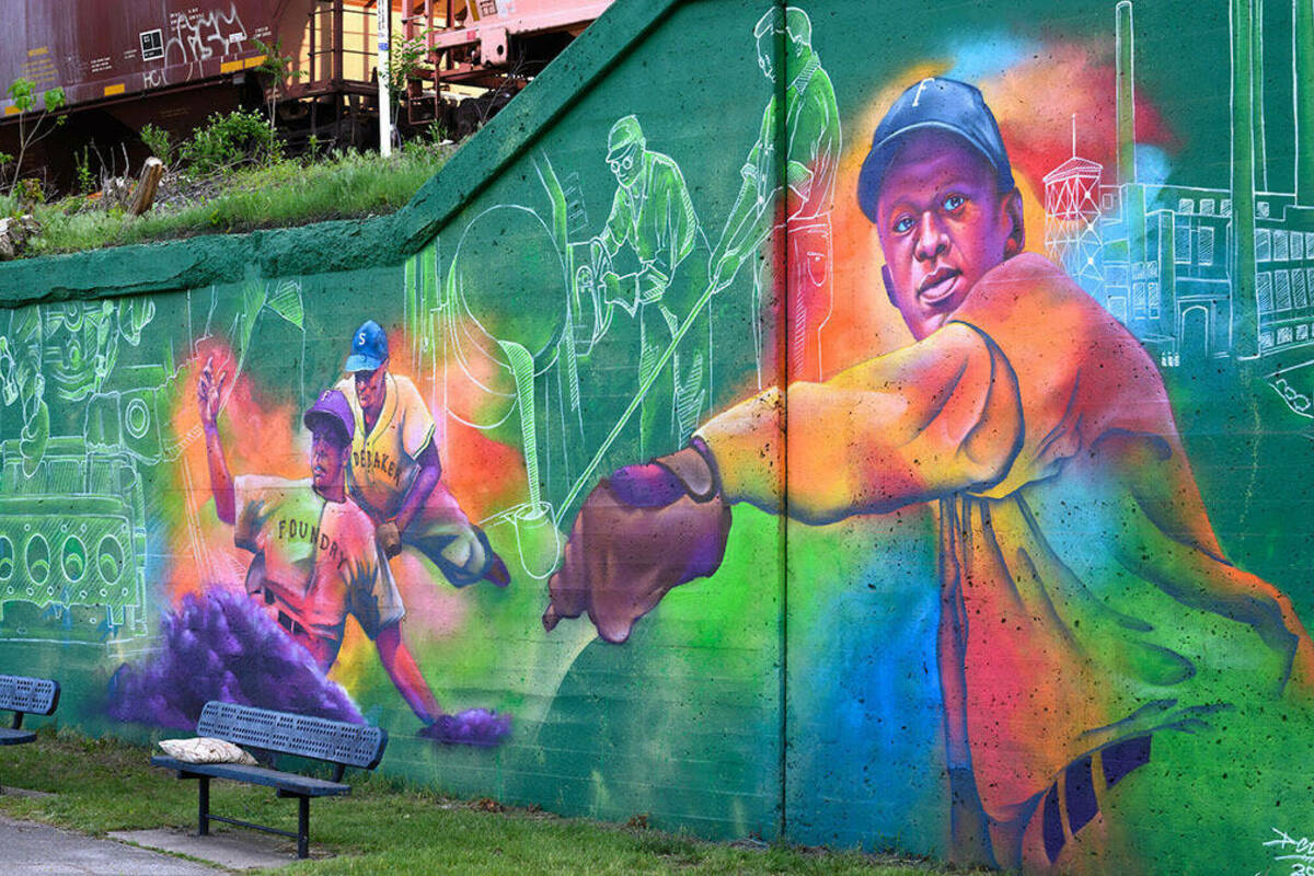 A colorful mural featuring images of Black baseball players from the past.