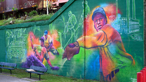 A colorful mural featuring images of Black baseball players from the past.