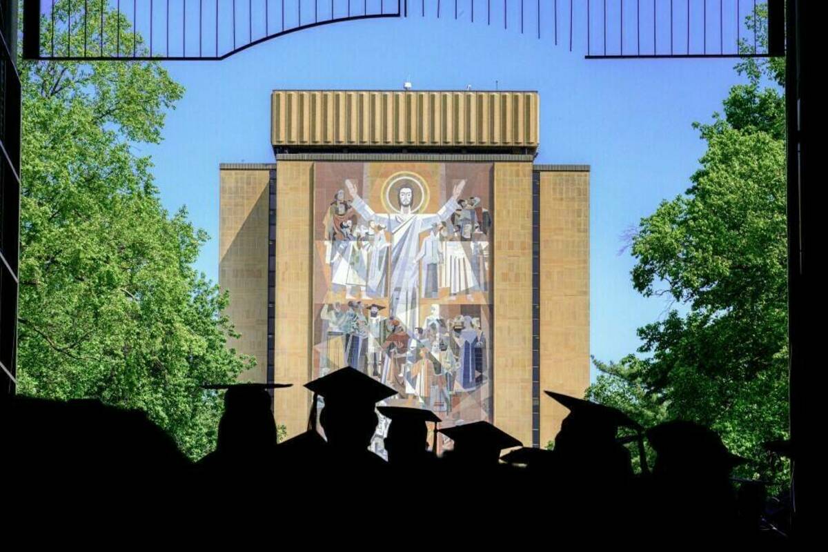Graduates process from the Stadium entrance towards the Word of Life mural on the Hesburgh Library. (photo by Matt Cashore/University of Notre Dame)