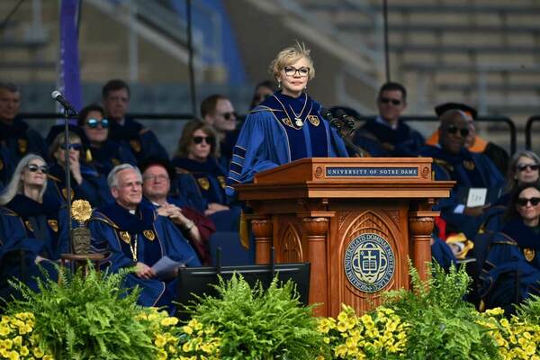 Claire Babineaux-Fontenot, chief executive officer of Feeding America, at the 2024 Commencement Ceremony in Notre Dame Stadium. She is wearing blue robes and glasses.