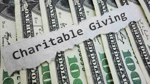 Graphic image of 100 dollar bills with a strip of paper running across it with the words "Charitable Giving" typed out on it.