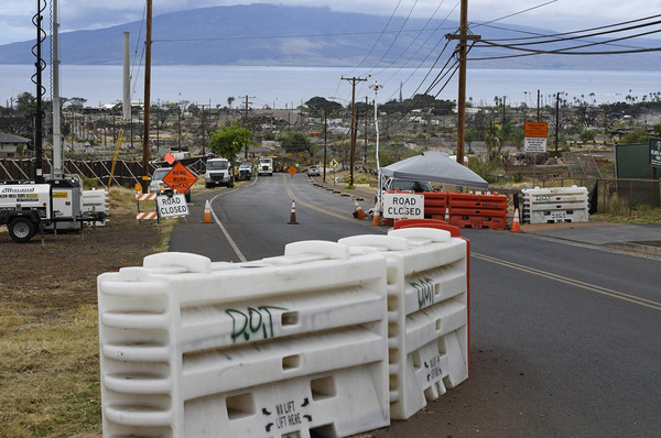 Street in Lahaina, Maui, with blockades and signage.