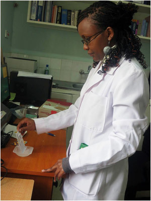 A Kenyan pharmacist uses a paper analytical device to test for counterfeit drugs